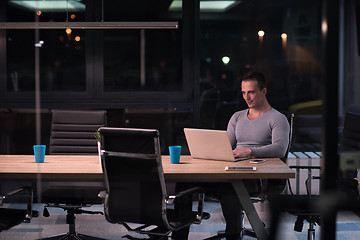 Image showing man working on laptop in dark office