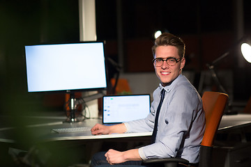 Image showing man working on computer in dark office