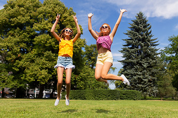 Image showing happy teenage girls jumping at summer park