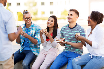 Image showing friends eating pizza and sandwiches in park