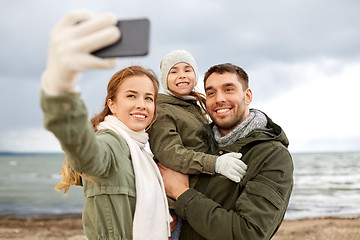 Image showing family taking selfie by smartphone on autumn beach