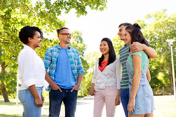 Image showing happy international friends talking in park