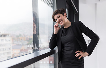 Image showing Elegant Woman Using Mobile Phone by window in office building