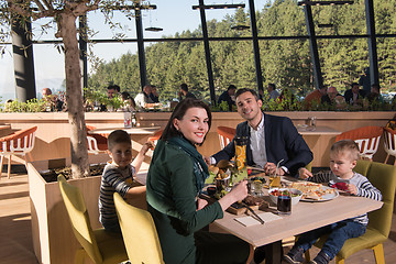 Image showing Young parents enjoying lunch time with their children