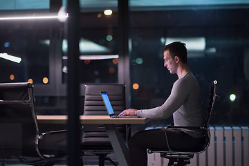 Image showing man working on laptop in dark office