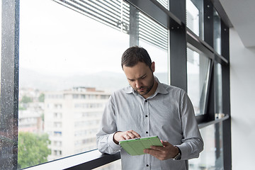 Image showing Businessman Using Tablet In Office Building by window