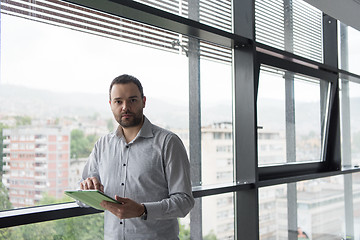 Image showing Businessman Using Tablet In Office Building by window