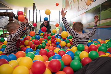 Image showing Young mom with her kids in a children\'s playroom