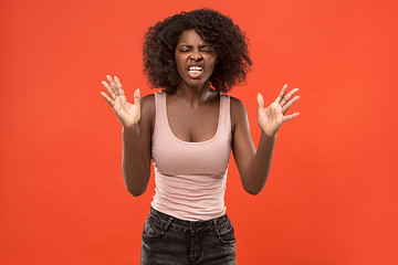 Image showing Beautiful female half-length portrait isolated on red studio backgroud. The young emotional surprised woman