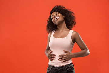 Image showing The happy business woman standing and smiling against red background.