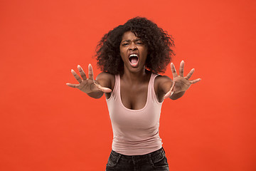 Image showing The young emotional angry woman screaming on red studio background