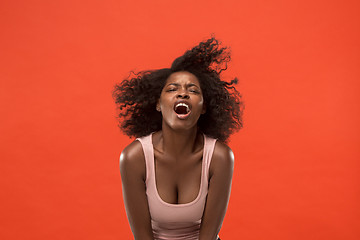 Image showing The young emotional angry woman screaming on red studio background