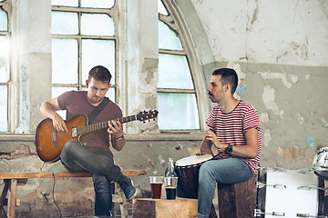 Image showing Repetition of rock music band. Electric guitar player and drummer behind the drum set.