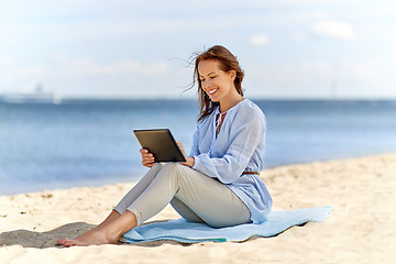 Image showing happy smiling woman with tablet pc on summer beach