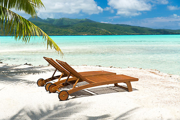 Image showing tropical beach with palm tree and sunbeds