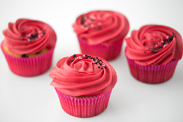 Image showing close up of cupcakes with red buttercream frosting