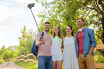 Image showing friends take picture by smartphone on selfie stick