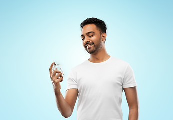 Image showing happy indian man with perfume over blue background