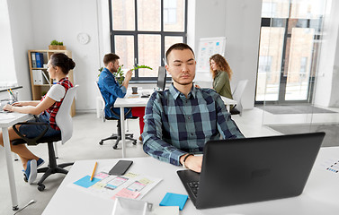 Image showing creative man with laptop working at office