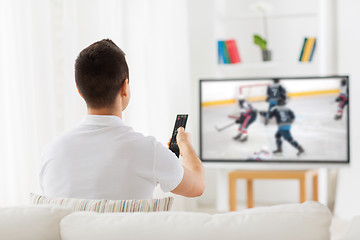 Image showing man watching ice hockey game on tv at home