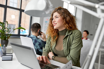 Image showing happy woman with computer working at office