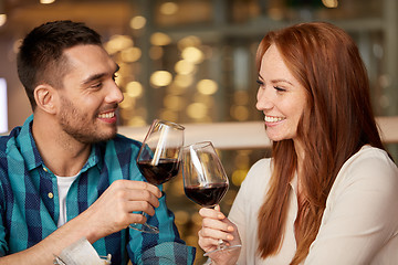 Image showing happy couple drinking red wine at restaurant