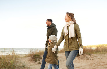 Image showing happy family walking along autumn beach