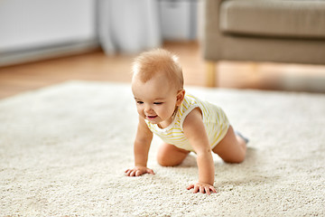 Image showing lovely baby girl crawling on floor at home