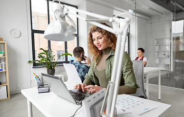Image showing creative woman with laptop working at office