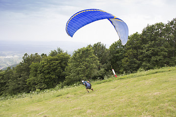 Image showing Paraglider taking off from the edge of the mountain