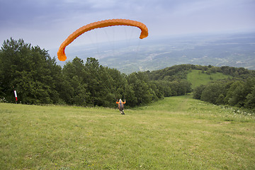 Image showing Paraglider taking off from the edge of the mountain