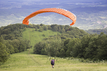 Image showing Paraglider taking off from the edge of the mountain