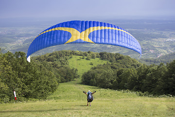 Image showing Paraglider taking off from the edge of the mountain