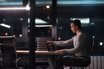 Image showing man working on laptop in dark office