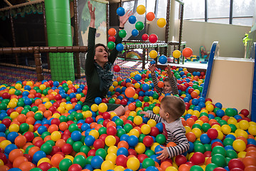 Image showing Young mom with her kids in a children\'s playroom