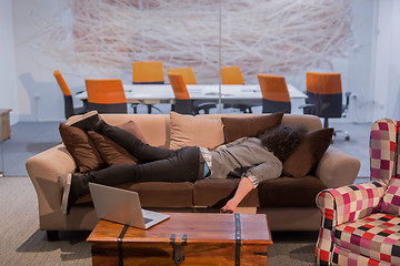 Image showing man sleeping on a sofa  in a creative office