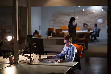 Image showing man working on computer in dark office