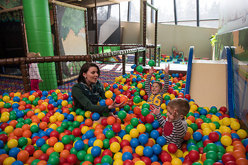Image showing Young mom with her kids in a children\'s playroom