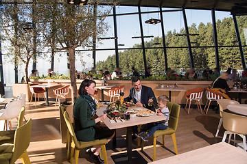 Image showing Young parents enjoying lunch time with their children