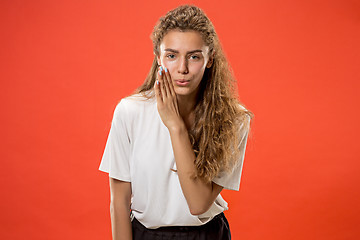 Image showing The young woman whispering a secret behind her hand