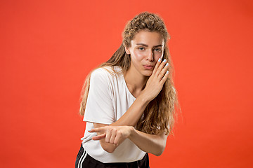 Image showing The young woman whispering a secret behind her hand