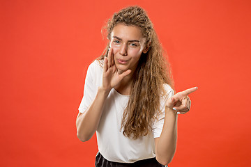 Image showing The young woman whispering a secret behind her hand