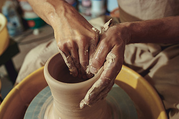 Image showing Creating a jar or vase of white clay close-up. Master crock.