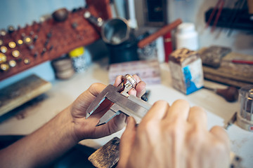 Image showing Different goldsmiths tools on the jewelry workplace. Jeweler at work in jewelry.