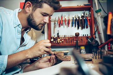 Image showing Different goldsmiths tools on the jewelry workplace. Jeweler at work in jewelry.