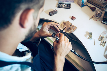 Image showing Different goldsmiths tools on the jewelry workplace. Jeweler at work in jewelry.