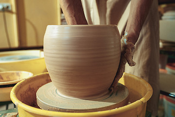 Image showing Creating a jar or vase of white clay close-up. Master crock.