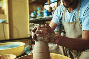 Image showing Creating a jar or vase of white clay close-up. Master crock.