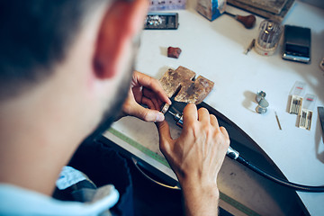 Image showing Different goldsmiths tools on the jewelry workplace. Jeweler at work in jewelry.