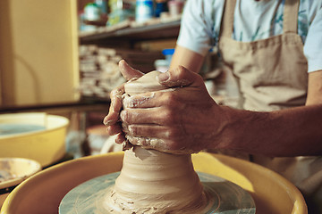 Image showing Creating a jar or vase of white clay close-up. Master crock.